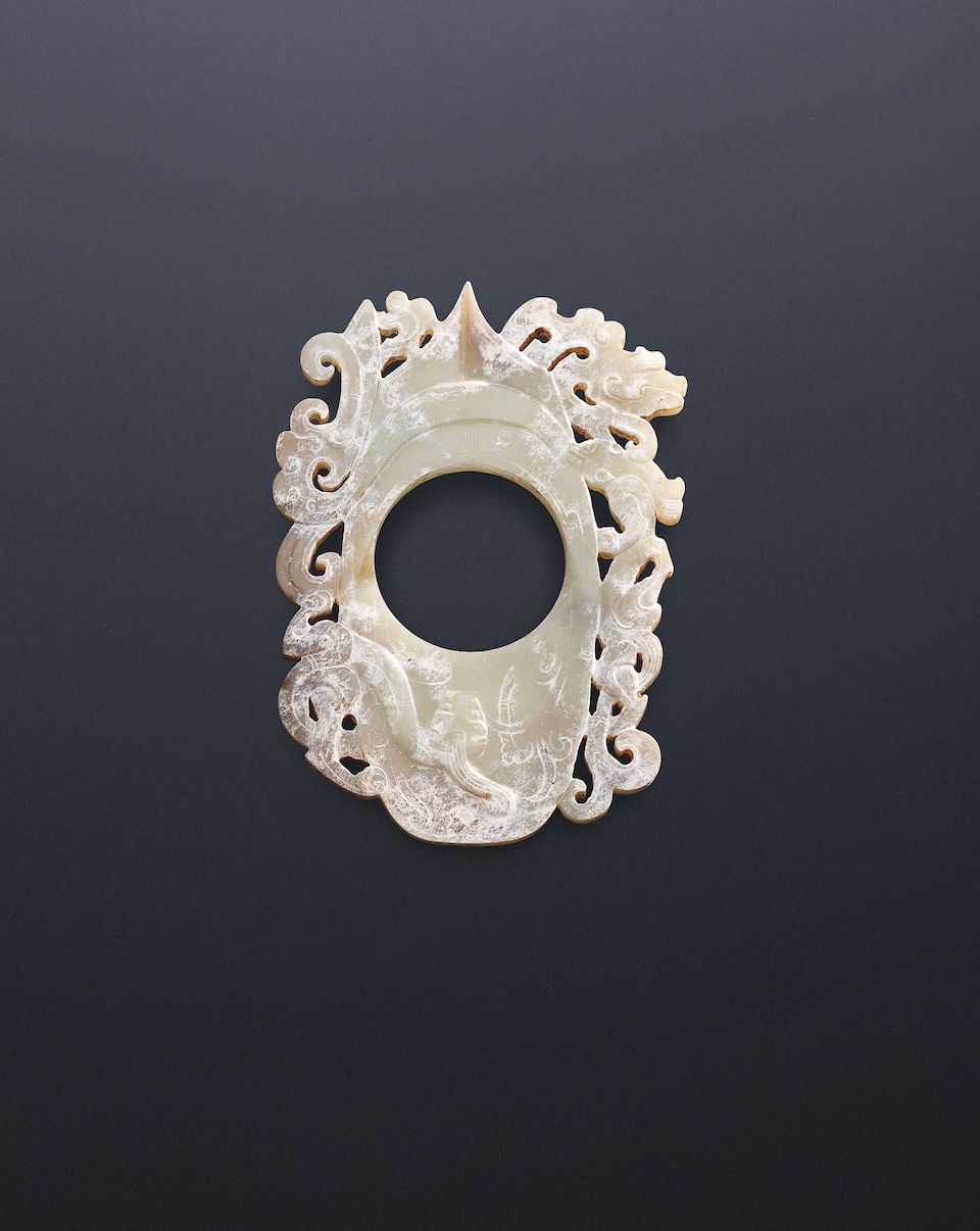 A large calcified pale green jade 'dragon' plaque Warring States Period