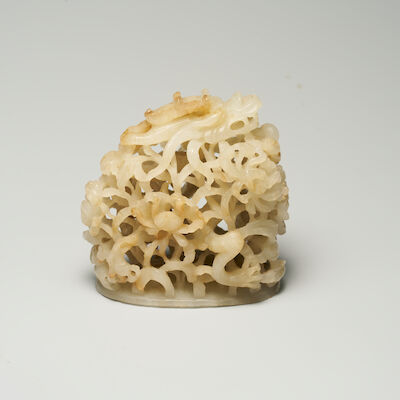 A GREYISH WHITE JADE 'DRAGON AND CHRYSANTHEMUM' HAT FINIAL 13th/14th century