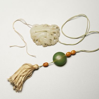 A RETICULATED WHITE JADE 'DRAGON' PENDANT Yuan or Ming Dynasty