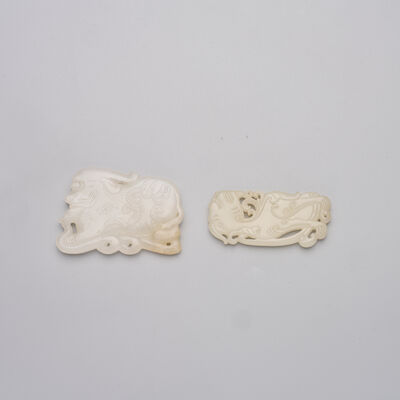 TWO WHITE JADE PENDANTS OF MYTHICAL BEASTS 19th/20th century (2)