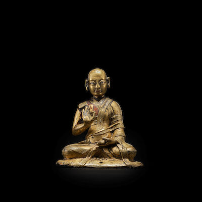 A SILVER AND COPPER INLAID COPPER ALLOY FIGURE OF A LAMA TIBET, 16TH CENTURY