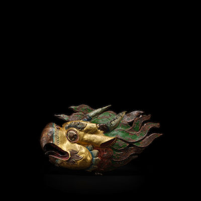 A GILT AND POLYCHROMED COPPER ALLOY REPOUSSE OF MAKHARA HEAD TIBET, 15TH CENTURY