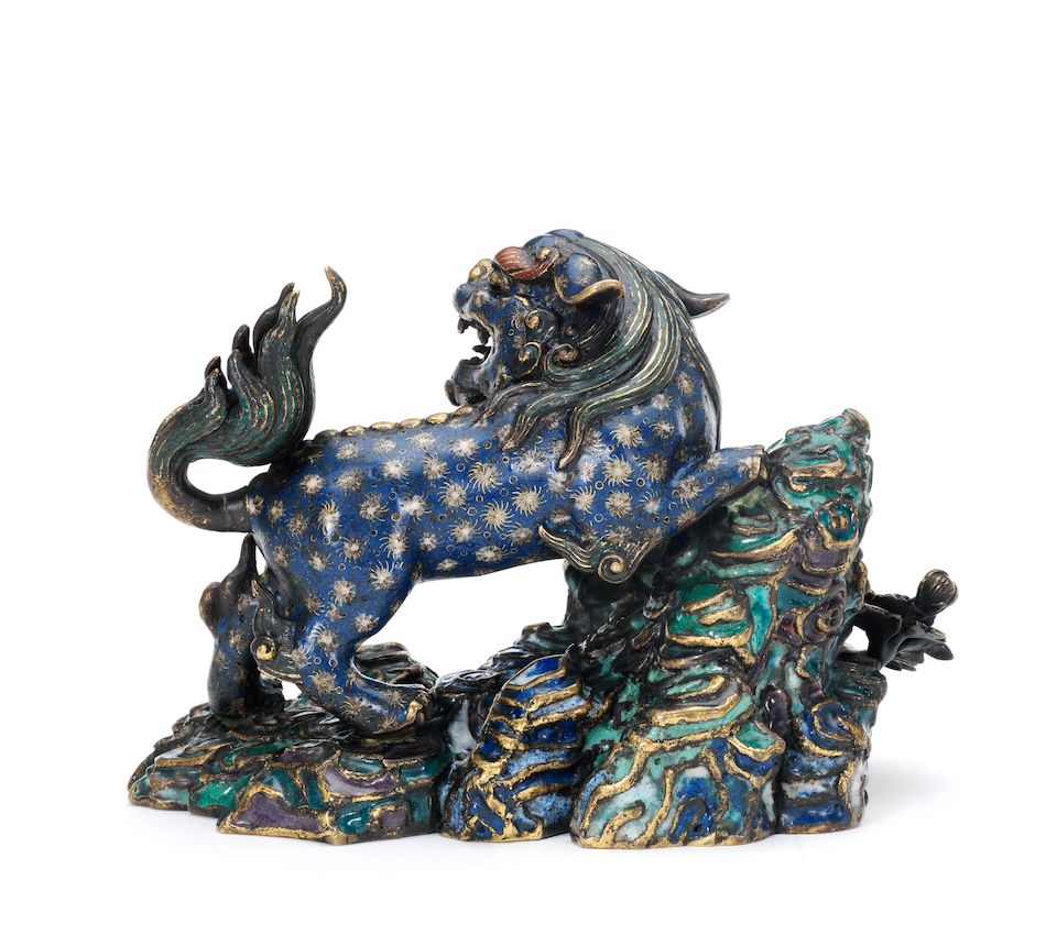 A rare cloisonné and champlevé enamel model of a Buddhist lion on rockwork 18th century