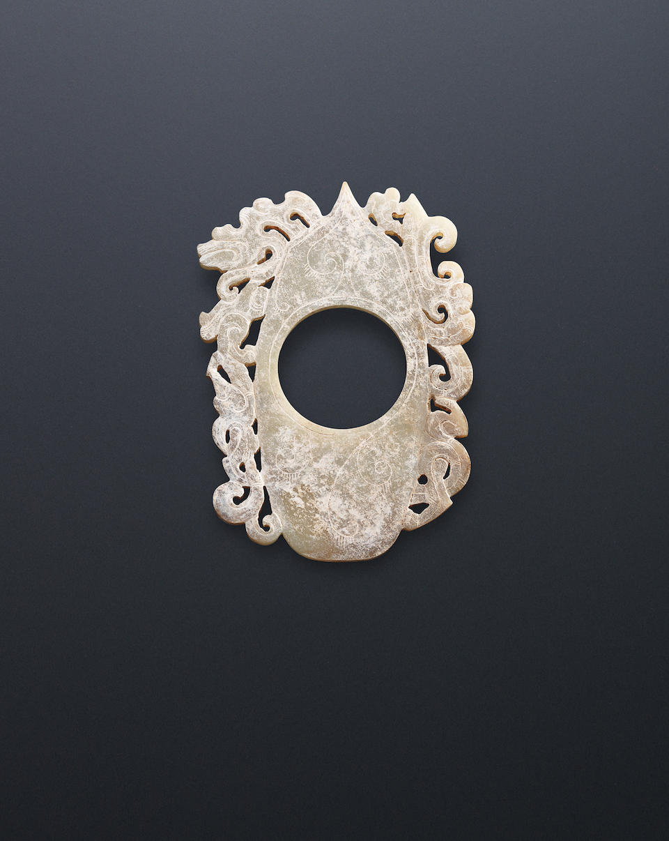 A large calcified pale green jade 'dragon' plaque Warring States Period
