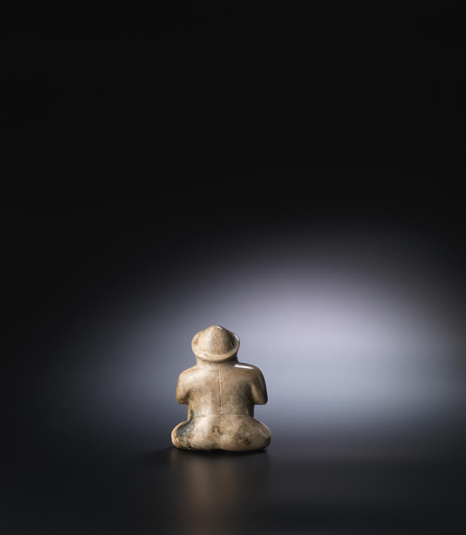 A rare pale brown jade seated male figure Eastern Han Dynasty