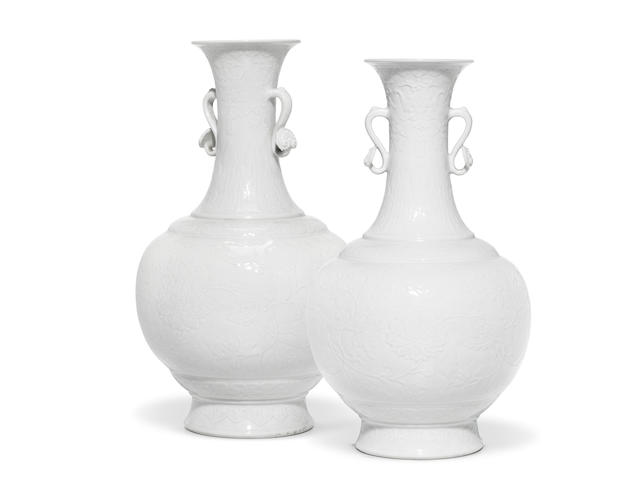 A very rare pair of Imperial white-glazed relief-carved bottle vases Qianlong seal marks and of the period (2)