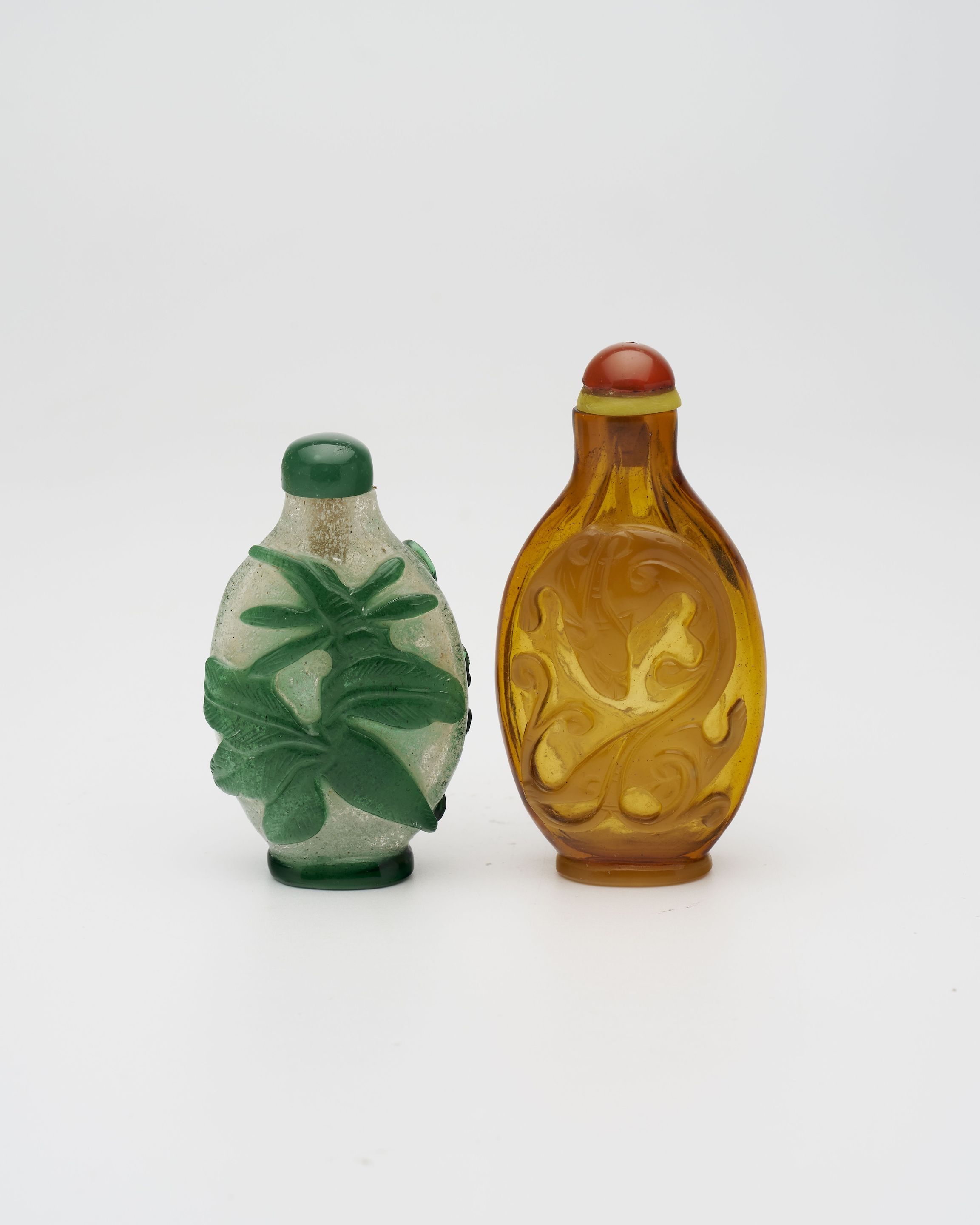 AN AMBER GLASS 'CHI DRAGON', AND A GREEN OVERLAY GLASS 'GRASSHOPPER AND CABBAGE' SNUFF BOTTLE 19th/20th century