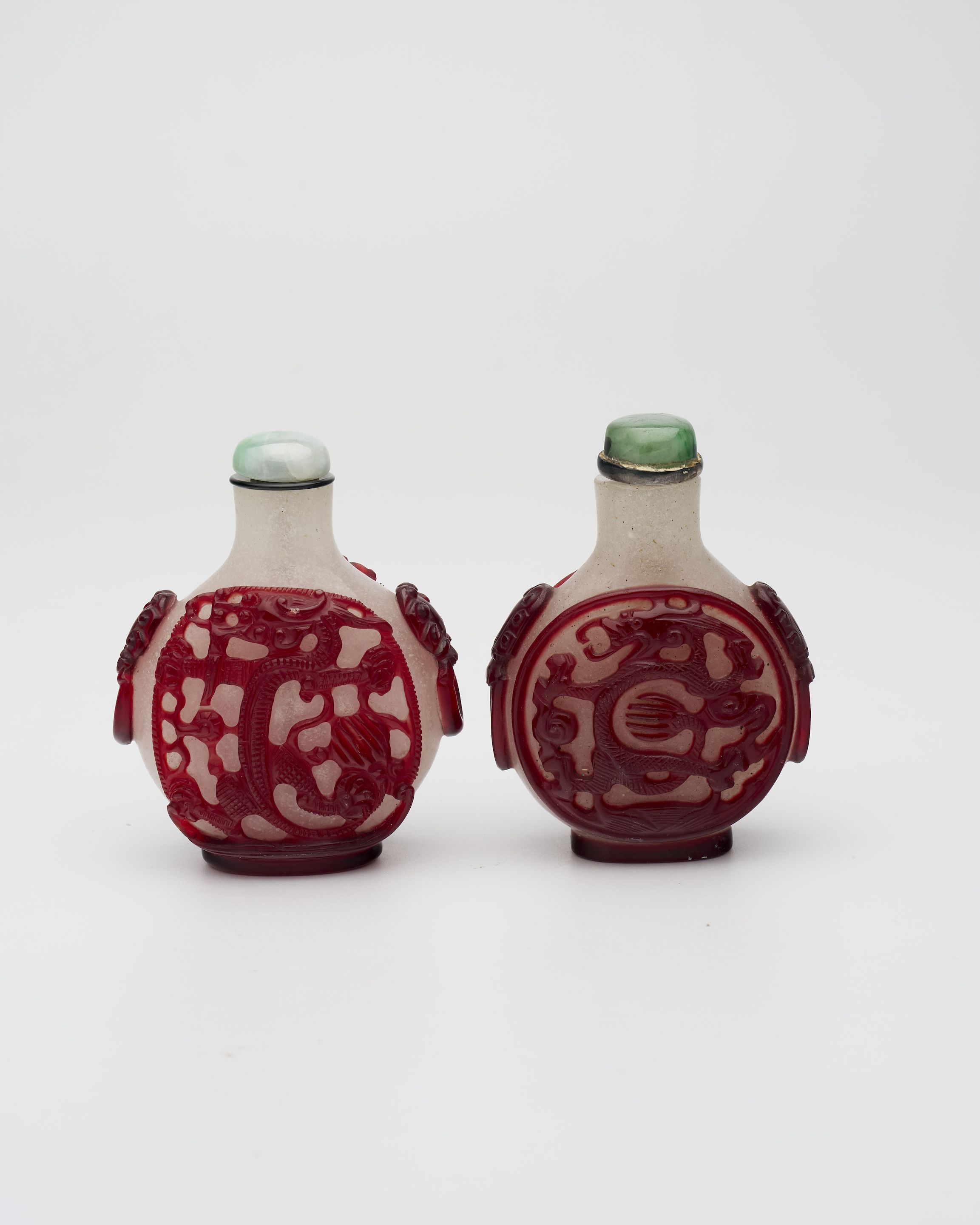 TWO RED OVERLAY GLASS 'DRAGON' AND 'TIGER' SNUFF BOTTLES Late Qing Dynasty