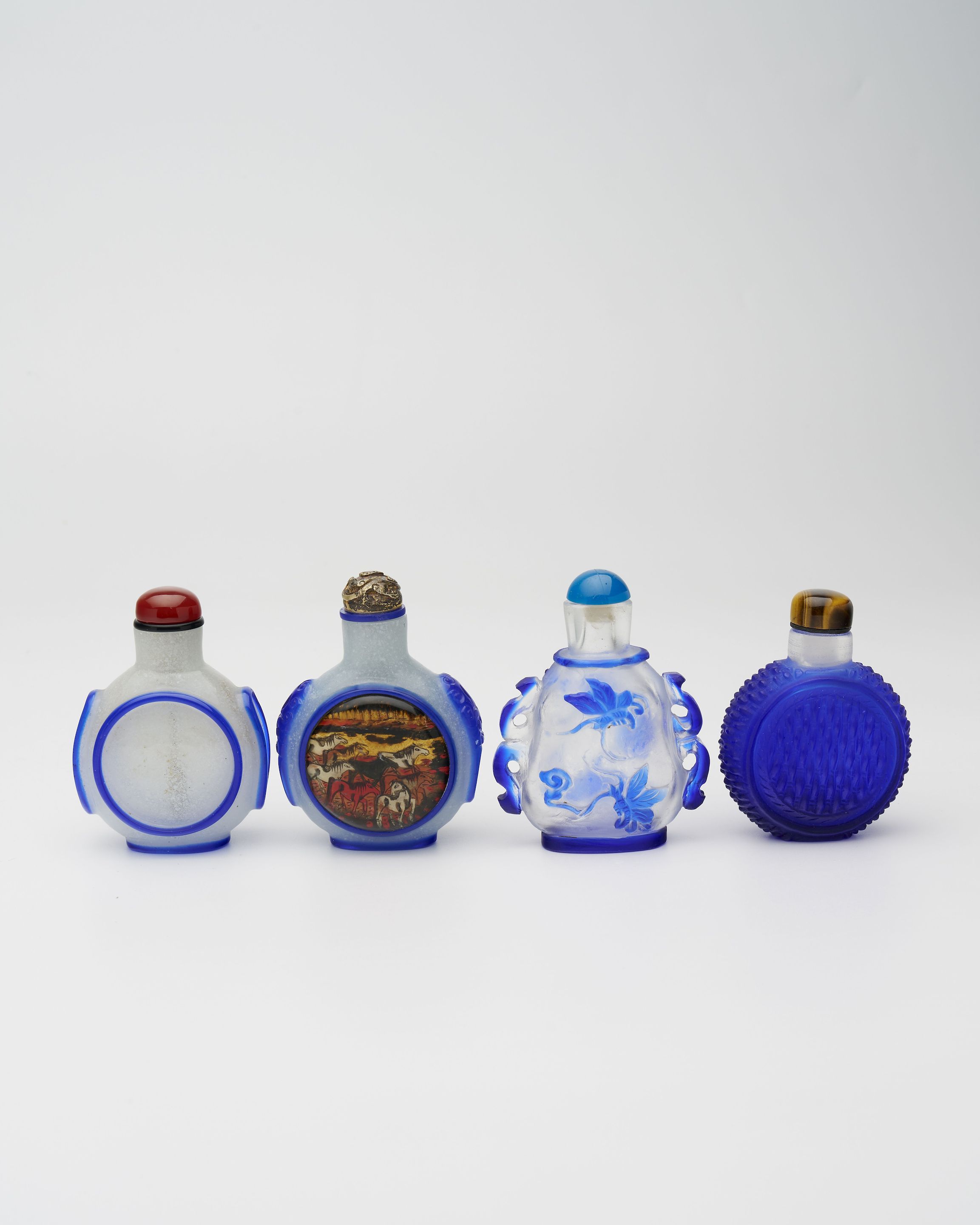 THREE BLUE OVERLAY GLASS AND A SAPPHIRE-BLUE GLASS SNUFF BOTTLES 19th/20th century